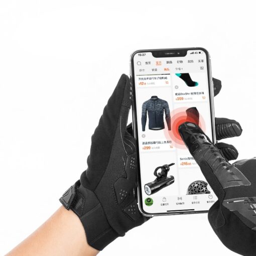 main manipulant un téléphone avec des gants chauffants